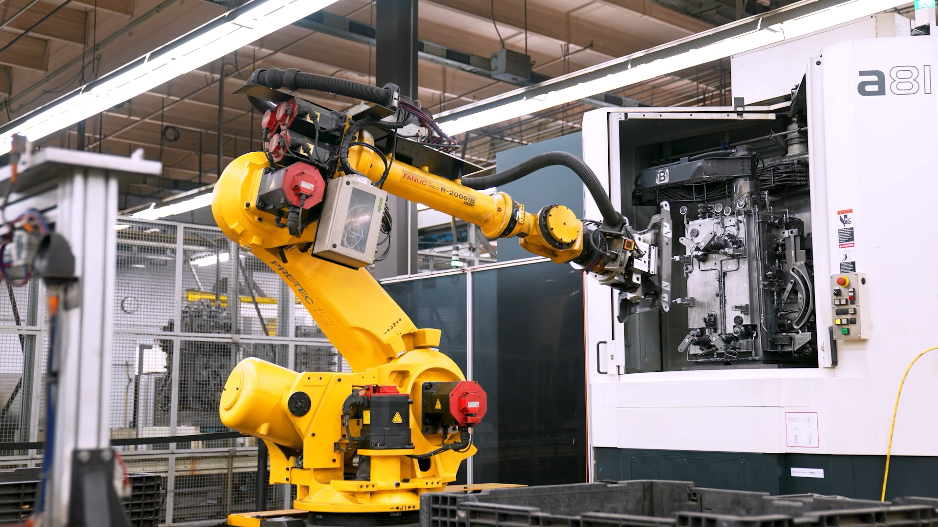 A yellow robotic arm performs automated manufacturing on dental chair components